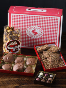 Gingham Classic Chocolate Trunk with pecan turtles, popcorn, truffles and English toffee displayed in open boxes