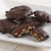 Dark Chocolate Pecan Turtles on a white plate.