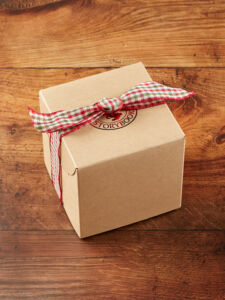 the box of holiday cheer which is a brown box with a red and green plaid bow.