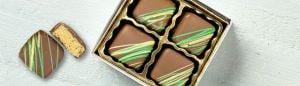 4pc gift box of dubai milk chocolates and 1 piece of a cut open dubai chocolate