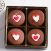 4 valentine's chocolate sandwich cookies with heart icing decals in a box