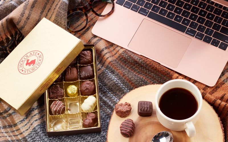 assorted chocolates, coffee, laptop and glasses for World Relaxation Day